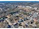 High-angle view of houses nestled among dense trees, with commercial buildings visible in the distance at 449 South Hill St., Buford, GA 30518