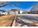 A gray home featuring an expansive backyard with a concrete patio and a low retaining wall, under a clear blue sky at 449 South Hill St., Buford, GA 30518