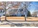 Charming home with mature tree in yard, featuring a quaint front porch, and a cheerful turquoise front door at 449 South Hill St., Buford, GA 30518