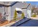 A home's exterior features a ramp, white railings, tidy landscaping, and an awning over a window, providing accessibility at 449 South Hill St., Buford, GA 30518