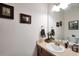 The bathroom features a vanity, decorative mirror, and framed pictures on the walls at 718 Fincher Rd, Covington, GA 30016