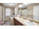 Neutral bathroom features a double vanity sink, a window, and a shower-tub with curtain at 718 Fincher Rd, Covington, GA 30016