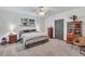 Comfortable bedroom features a window, ceiling fan, wardrobe, and decorative wooden furniture at 718 Fincher Rd, Covington, GA 30016