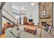 Spacious living room featuring a stone fireplace, hardwood floors, and an open staircase to upper level at 718 Fincher Rd, Covington, GA 30016