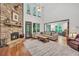 Bright and airy living room featuring a stone fireplace, hardwood floors, and open access to a dining area at 718 Fincher Rd, Covington, GA 30016