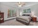 Main bedroom featuring large windows, a ceiling fan, and neutral carpeting at 718 Fincher Rd, Covington, GA 30016