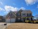 Charming two-story home with a manicured lawn, two-car garage, and an inviting front porch at 209 Crestmont Way, Canton, GA 30114