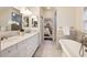 Elegant bathroom featuring marble countertops, a soaking tub, and a separate glass-enclosed shower at 2508 Brookwood Ne Dr, Atlanta, GA 30305