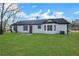 Lush green lawn surrounds the rear of this lovely light and bright home with white siding and black trim at 2964 Hollow Ln, Powder Springs, GA 30127