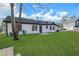 A lush green lawn surrounds the rear of this lovely, light and bright home with white siding and black trim at 2964 Hollow Ln, Powder Springs, GA 30127