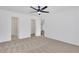 This bedroom features neutral carpeting, white walls, a ceiling fan, and access to an ensuite bathroom and walk-in closet at 2964 Hollow Ln, Powder Springs, GA 30127
