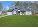 This home features a lush green lawn, white siding, gray accents, and a one-car garage at 2964 Hollow Ln, Powder Springs, GA 30127