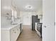 Bright kitchen features quartz counters, stainless appliances, white cabinets, and wood-look flooring at 2964 Hollow Ln, Powder Springs, GA 30127