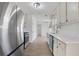 Long galley kitchen featuring stainless steel appliances, white cabinets, and subway tile backsplash at 2964 Hollow Ln, Powder Springs, GA 30127
