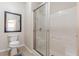 Bright bathroom featuring a glass-enclosed shower and a classic framed mirror above the toilet at 4479 Caleb Xing, Powder Springs, GA 30127