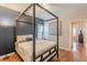 Bedroom with stylish canopy bed, dark blue accent wall, and hardwood flooring at 4479 Caleb Xing, Powder Springs, GA 30127
