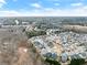 A residential neighborhood aerial shot that includes a beautiful blue sky above a mix of greenery and homes at 3650 Bentbill Xing, Cumming, GA 30041