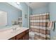 A full bathroom with a shower and tub combination, decorated with a neutral striped shower curtain at 3650 Bentbill Xing, Cumming, GA 30041