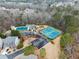 Aerial view of community pool, tennis courts, playground, and clubhouse surrounded by trees at 3650 Bentbill Xing, Cumming, GA 30041