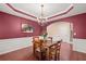 This dining room features beautiful woodwork, hardwood floors, and a modern chandelier at 3650 Bentbill Xing, Cumming, GA 30041