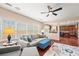 Bright and airy living room featuring hardwood floors, large windows, and an open layout with a view into the kitchen at 3650 Bentbill Xing, Cumming, GA 30041