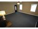 Bright living room with a ceiling fan, two windows and dark carpeting at 4973 Horton Pl, Douglasville, GA 30135