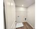 A well-lit laundry room with wood-look flooring, shelving and a white utility tray at 2359 Brown Dove Way (Lot 2), Grayson, GA 30017