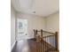 Upstairs hallway with hardwood floors, iron railing, and natural light streaming in from the nearby doorway at 639 Brennan Dr, Decatur, GA 30033