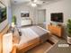 Staged bedroom featuring neutral tones, a ceiling fan, a TV, and a mirrored closet at 80 Colony Ridge Dr, Alpharetta, GA 30022