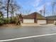 This home has a two-car garage with white doors and a well-manicured lawn surrounded by mature trees at 80 Colony Ridge Dr, Alpharetta, GA 30022