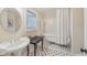 Charming bathroom featuring a clawfoot tub, pedestal sink, and black and white tiled flooring at 9865 Buice Rd, Alpharetta, GA 30022