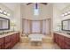 Elegant bathroom featuring a soaking tub, large vanity with double sinks and a view of the window at 9865 Buice Rd, Alpharetta, GA 30022