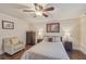 Traditional bedroom with a ceiling fan, wood floors, and decorative accents at 9865 Buice Rd, Alpharetta, GA 30022