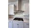 Modern kitchen with stainless steel range hood, white cabinets, and herringbone backsplash at 1055 Dryden Ln # 10, Atlanta, GA 30319