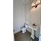 Elegant powder room with pedestal sink, modern lighting, and wood flooring at 1055 Dryden Ln # 10, Atlanta, GA 30319