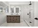 Bathroom with double sink vanity, illuminated mirrors, and glass enclosed shower featuring a rainfall shower head at 2670 Thornbury Way, Atlanta, GA 30349