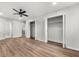 Hardwood floors and light paint throughout the large bedroom with a ceiling fan and ensuite bath at 2670 Thornbury Way, Atlanta, GA 30349