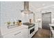 Modern white kitchen featuring stainless steel appliances, and stylish tile backsplash at 3015 Woodvale Ct, Alpharetta, GA 30022