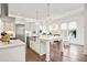 Modern white kitchen with stainless steel appliances, granite countertops, and stylish lighting at 3015 Woodvale Ct, Alpharetta, GA 30022