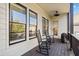 A covered porch features wood-look decking and two rocking chairs overlooking the backyard at 3015 Woodvale Ct, Alpharetta, GA 30022