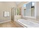 Bathroom features a soaking tub with tiled surround and a window providing natural light at 3232 Cates Ne Ave, Brookhaven, GA 30319