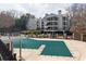 Community pool with a green safety covering and the gray siding of a multi-story building at 602 Granville Ct, Sandy Springs, GA 30328