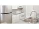 Close-up of kitchen with stainless steel refrigerator, electric range, white cabinets, and granite countertop at 602 Granville Ct, Sandy Springs, GA 30328