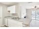 Kitchen area featuring gray countertops, stainless steel sink and modern appliances, with view to living area at 602 Granville Ct, Sandy Springs, GA 30328