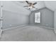 A light gray bedroom with a ceiling fan, a window, and plush gray carpet at 907 Fox Croft Pl, Canton, GA 30114