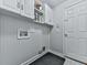 Functional laundry room with white cabinets, beadboard paneling, and tiled flooring at 907 Fox Croft Pl, Canton, GA 30114