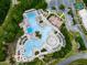 Aerial view of a large community pool, complete with ample seating and a splash pad, adjacent to green spaces at 907 Fox Croft Pl, Canton, GA 30114