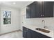 Laundry room with navy cabinets, tile flooring, and a window for natural light at 1445 Ashwoody Ne Ct, Atlanta, GA 30319