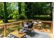 Inviting outdoor deck with wood furniture and a stylish rug, surrounded by lush greenery at 1788 Piper Se Cir, Atlanta, GA 30316