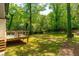 Lush backyard with a wooden deck, outdoor seating, and ample shade from mature trees at 1788 Piper Se Cir, Atlanta, GA 30316